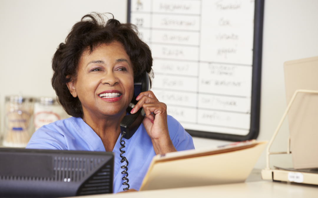 A woman answers a phone call in a healthcare facility. The call is recorded and must be stored for 7 years, so she needs a call recording retention and retrieval solution.